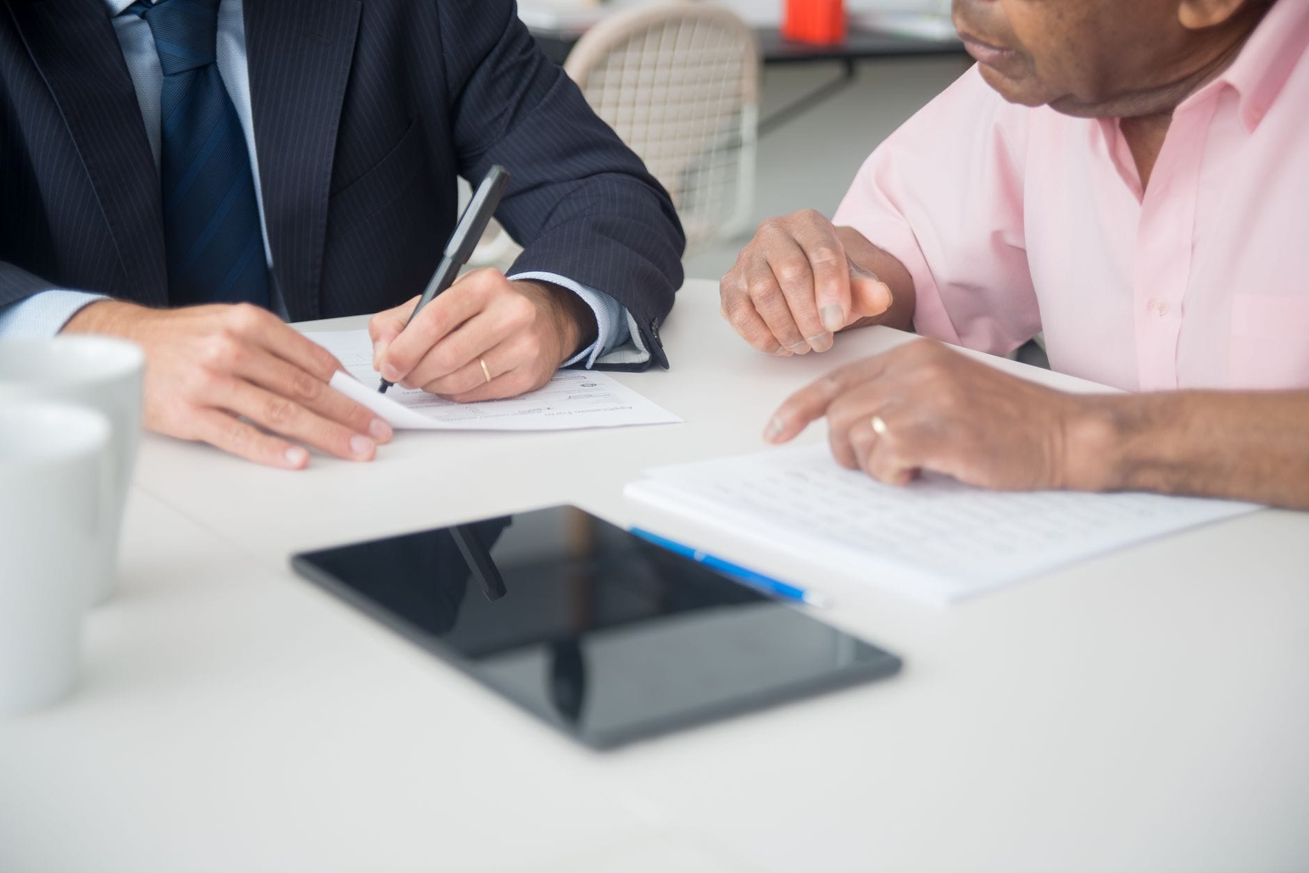 Two people finalizing an agreement at a sunlit table
